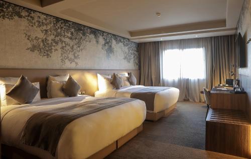 a hotel room with two beds and a window at Villa Blanca Urban Hotel in Casablanca