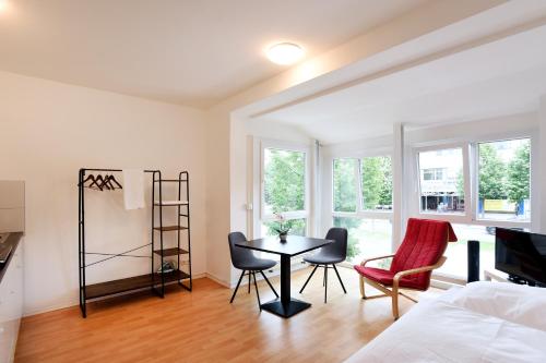 een slaapkamer met een tafel en stoelen en een bed bij Apartments EFDE GmbH in Heilbronn