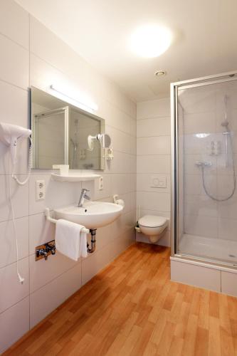 a bathroom with a sink and a shower and a toilet at Apartments EFDE GmbH in Heilbronn