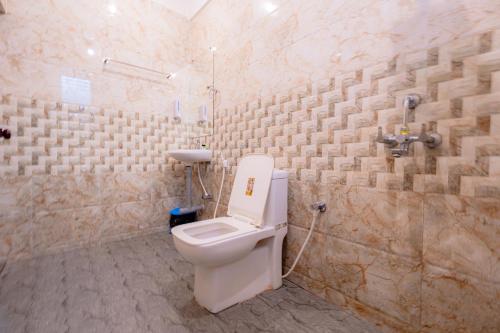 Viik wellness inn -3 Star Resort in Arambol Beach في أرامبول: حمام مع مرحاض في جدار حجري