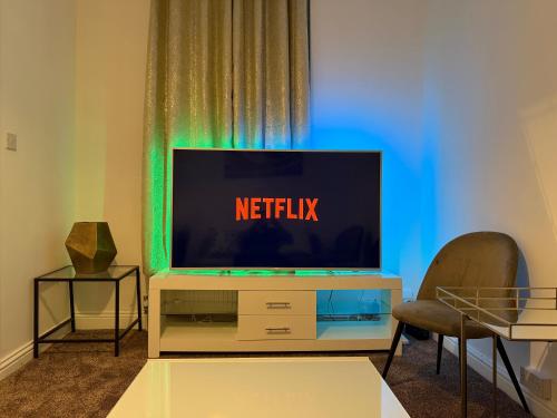 a flat screen tv sitting on top of a entertainment center at 2 Bedroom Wakefield City Centre House With All Ensuite Rooms in Wakefield