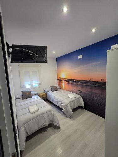 a bedroom with two beds and a painting on the wall at Apartamento Luxury Home Huelva Zona centro in Huelva