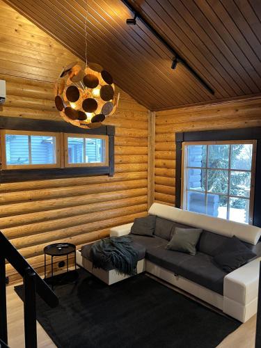 a living room with a couch in a room with wooden walls at Arvoneliöt Lomahimos 18 in Jämsä