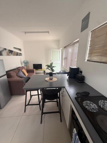 Sunny Snooze Holiday Home في جودوود: مطبخ وغرفة معيشة مع طاولة في مطبخ