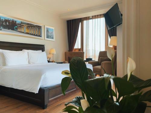 a hotel room with a bed and a couch at Maccal Boutique Hotel Dalat in Da Lat