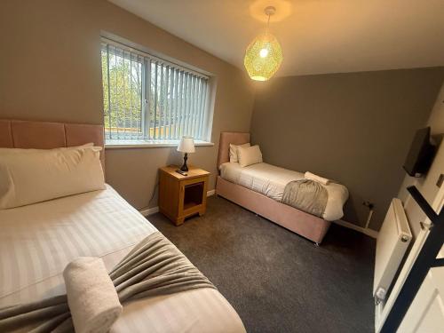 a small bedroom with two beds and a window at Rose Cottage by Sasco in Blackpool
