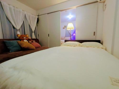 a bedroom with a large white bed with a teddy bear at The Akasaka roppongi Central Stay in Tokyo