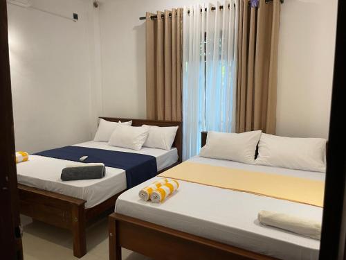 two beds in a room with curtains andskirts at Delight Villa - Ahangama in Ahangama