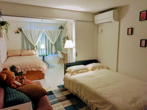 a bedroom with two beds and a teddy bear at The Akasaka roppongi Central Stay in Tokyo