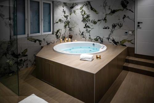 a bathroom with a large tub with a glass door at Vacation Home Mo Star with Swimming pool and Sauna in Mostar