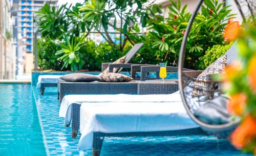 a pool with tables and chairs next to a swimming pool at Intercity Hotel & Serviced Apartment Phnom Penh Downtown in Phumĭ Prêk Chrey