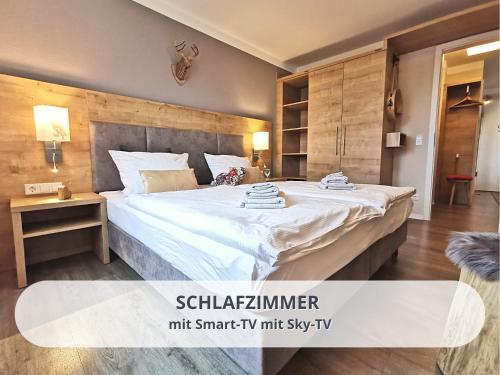 a bedroom with a large bed in a room at FeWo Schwarzwaldschick Feldberg I Bergurlaub I Balkon I Whirlwanne I Tiefgarage I HochschwarzwaldCard inkl in Feldberg