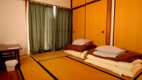 Postel nebo postele na pokoji v ubytování 木の家ゲストハウス小山西口館