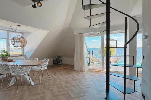 a dining room with a table and a spiral staircase at Lake House 10 - 4 Person Lake view apartment! in Offingawier