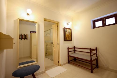 a bathroom with a bench and a walk in shower at Gaj Kesri by 7Apple Resorts in Bikaner