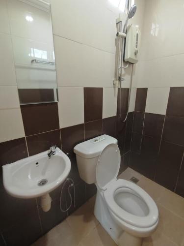 a bathroom with a toilet and a sink at D Teratak Motel in Kuah