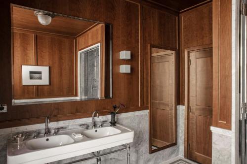 a bathroom with two sinks and a mirror at Hôtel Balzac Paris & Spa Ikoï in Paris