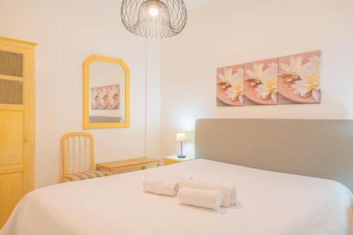 una camera da letto con un letto bianco con asciugamani sopra di Torre da Rocha 601A a Praia da Rocha