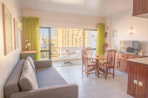 un soggiorno con un divano, un tavolo e una cucina di Torre da Rocha 601A a Praia da Rocha