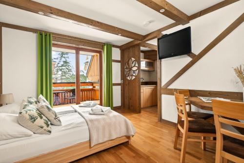 a bedroom with a bed and a table and a television at Willa Vera Zakopane in Zakopane