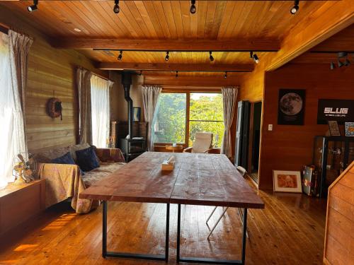 Una sala de estar con una mesa de madera y un sofá. en カタツムリ, en Shiogama
