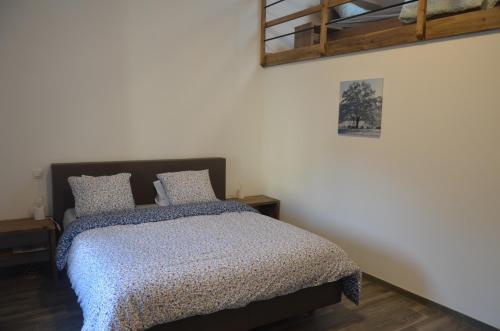 a bedroom with a bed and a picture on the wall at Au pied de La Redoute in Sougné-Remouchamps