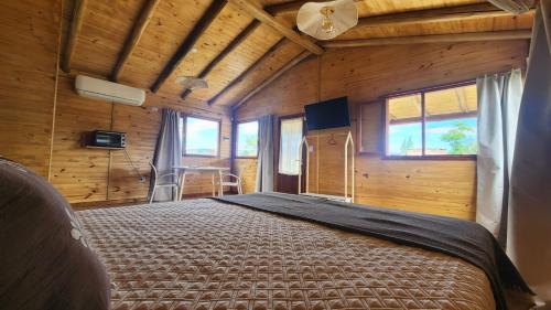 una camera da letto con un letto in una stanza con pareti in legno di Cabañas Potrero de Marquez Paraiso Adult only a Potrero de Garay