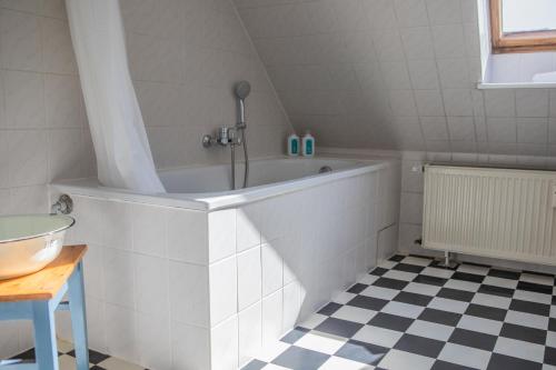a bath tub in a bathroom with a checkered floor at Markt Eins Appartement Stadtblick in Schöppenstedt