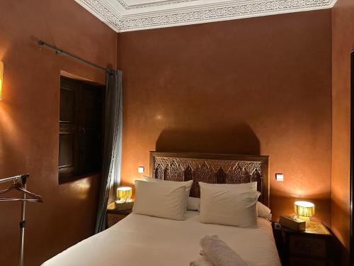 a bedroom with a bed with white sheets and pillows at Riad Jadis in Marrakesh
