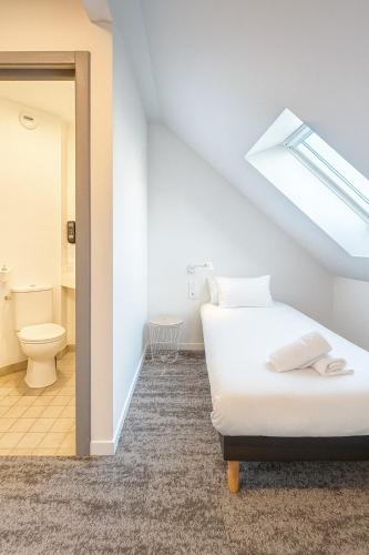 a attic bedroom with a bed and a toilet at Hôtel restaurant Relais de Rixheim Ile Napoléon Mulhouse in Rixheim