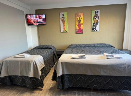 a hotel room with two beds and a tv at Monoambiente céntrico in Comodoro Rivadavia
