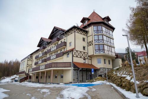 ein großes Gebäude auf einem schneebedeckten Hügel in der Unterkunft Santa Christina in Świeradów-Zdrój