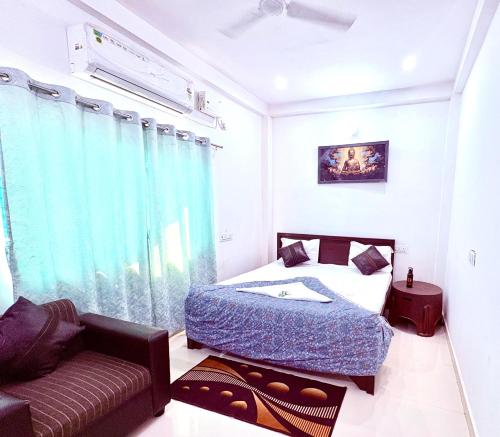 un dormitorio con una cama y un sofá en Majestic Inn Home Stay, en Varanasi