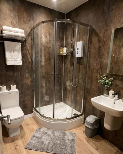 a bathroom with a shower and a toilet and a sink at City Centre Premier Executive Apartments in Sunderland