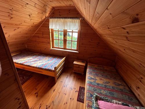 Ένα ή περισσότερα κρεβάτια σε δωμάτιο στο Domek z bala Mazury