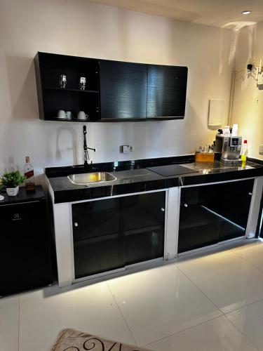 una cocina con encimeras en blanco y negro y fregadero en Latinos Casa with pool, en Maragogi