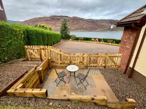 a backyard with a wooden fence and a table and chairs at Balcarres Self Catering in Fort William