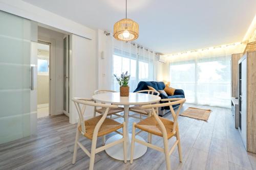 a dining room and living room with a table and chairs at Hauzify I Apartament Kempenland in Salou