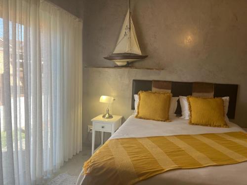 a bedroom with a large bed with yellow pillows at Revival House Shalom in Jeffreys Bay