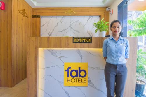 a woman standing in front of a wall with aida hotels sign at FabHotel Bohra International in Jaipur