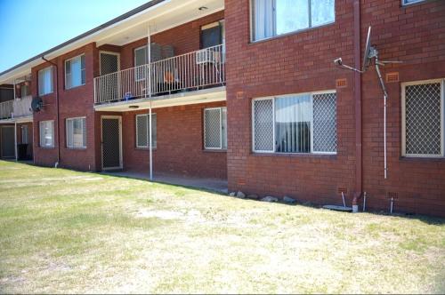 un edificio de ladrillo rojo con un patio delante en Harbour Lane Stay, en Geraldton