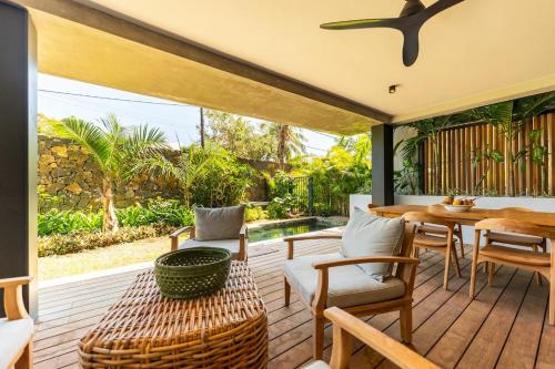 a patio with a table and chairs and a pool at Modern and comfortable apartment in Pointe aux Cannoniers
