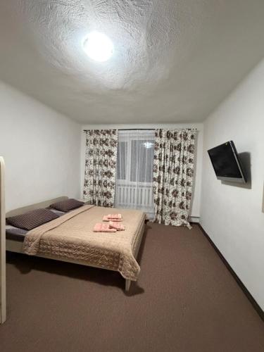 a bedroom with a bed and a window at Garage in Yaremche