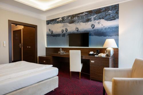 a hotel room with a bed and a desk and a television at Hotel Falko in Rumia