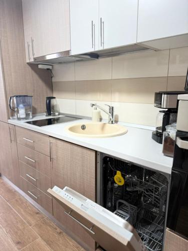 an open dishwasher in a kitchen with a sink at Casa MIO in Braşov
