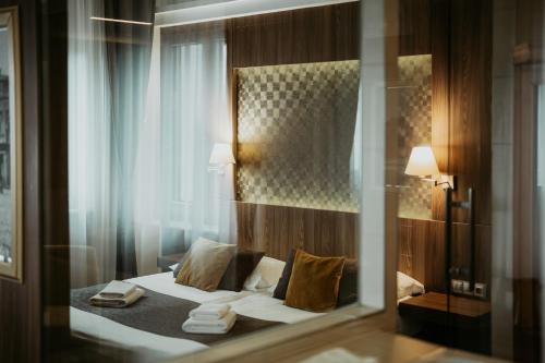 a hotel room with a bed and a mirror at Duna Wellness Hotel in Baja
