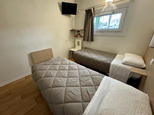 a small room with a bed and a window at Première Classe Rennes sud Est in Chantepie