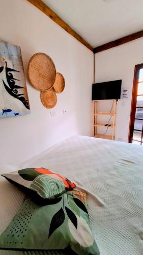 una camera da letto con un letto con un cuscino sopra di Suíte Capiá a Ubatuba