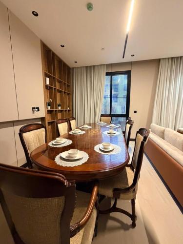 a dining room with a wooden table and chairs at Luxury Apartment شقه الفخامه في المونسيه in Riyadh