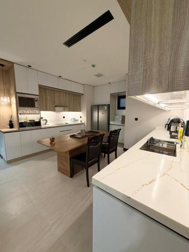 a large kitchen with a table and chairs in it at Luxury Apartment شقه الفخامه في المونسيه in Riyadh